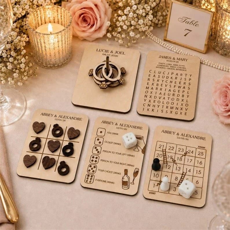 Five engraved birch plywood table game cards with wooden pieces on a wedding table
